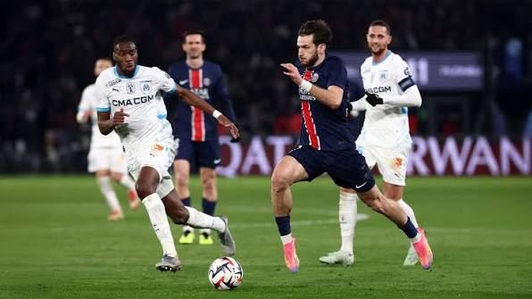 Joueurs de Marseille et du PSG disputant un match au stade
